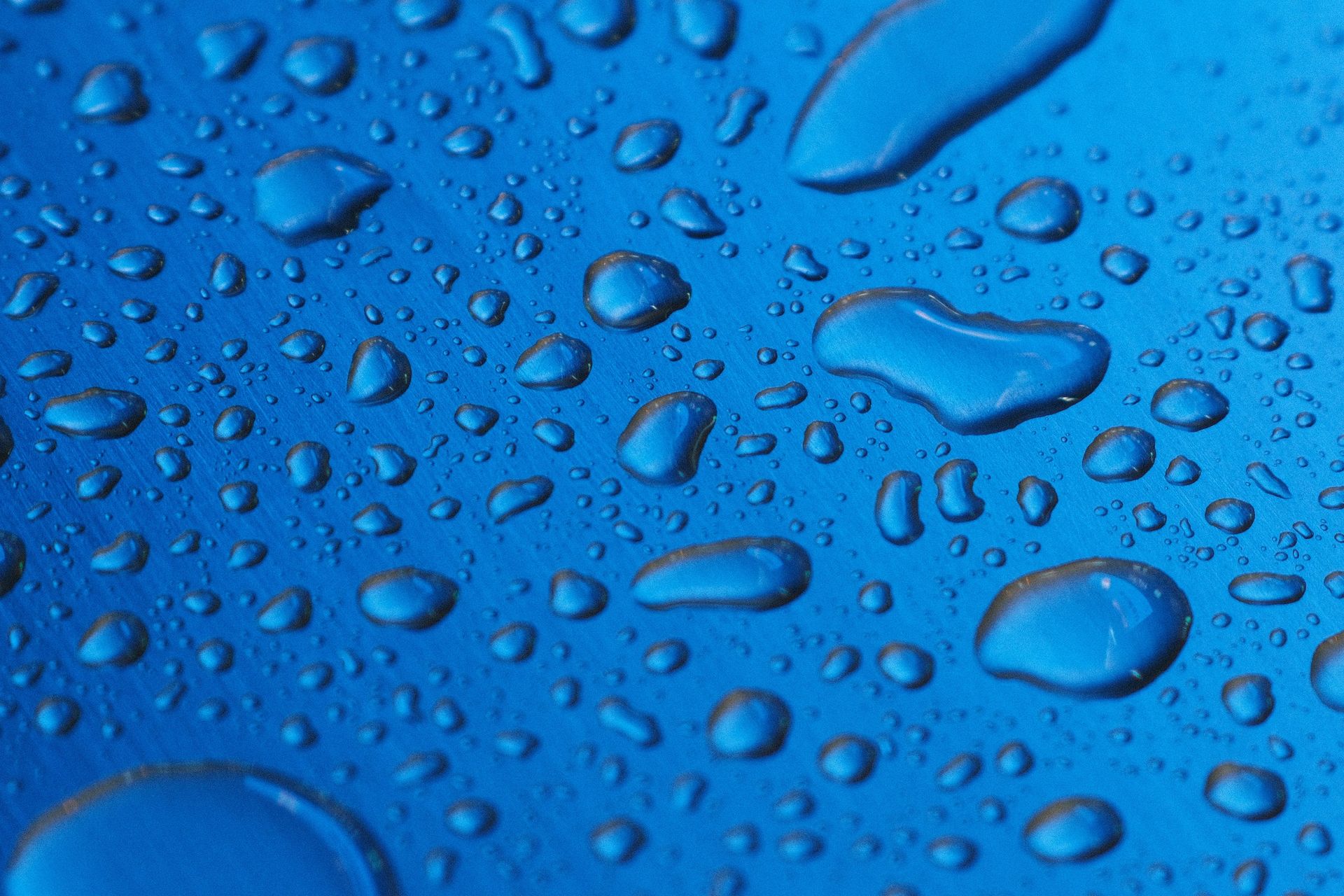 Water beading on a smooth blue surface